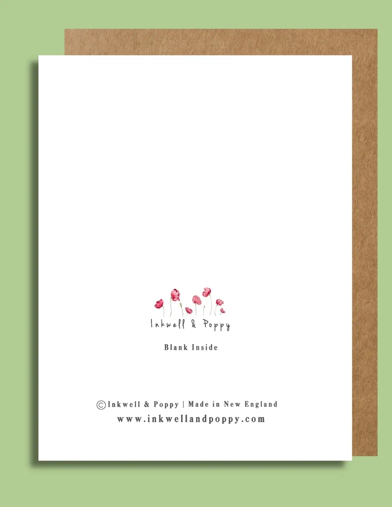Blank handcrafted greeting card with small pink poppy artwork, kraft envelope on green background